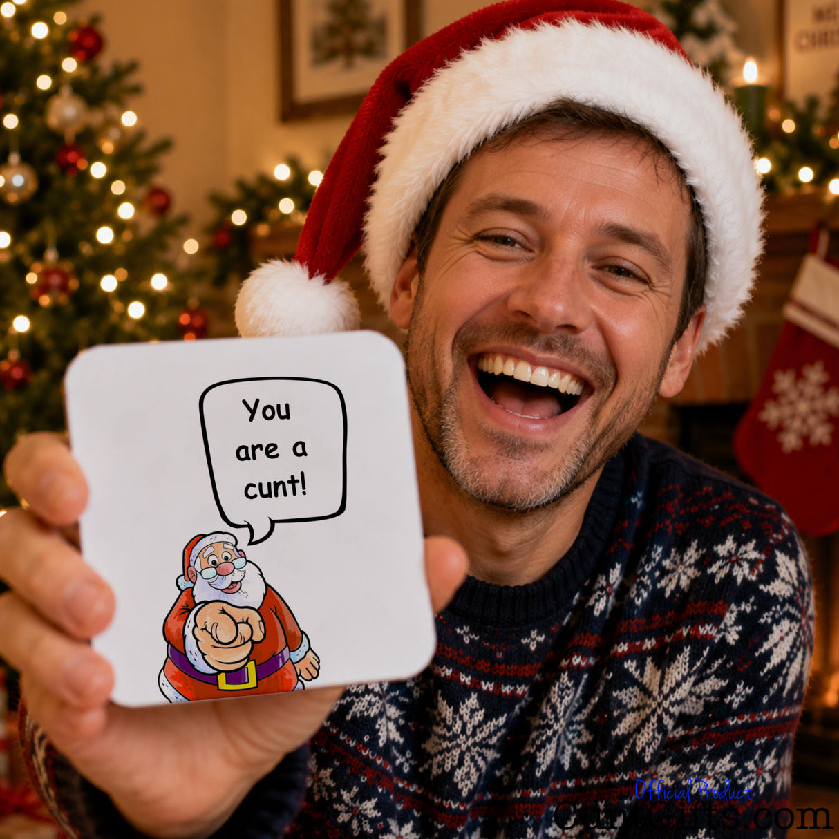 Santa says your a cunt drink coaster held by laughing man with beard in Christmas hat with tree and festive scene in ackground.