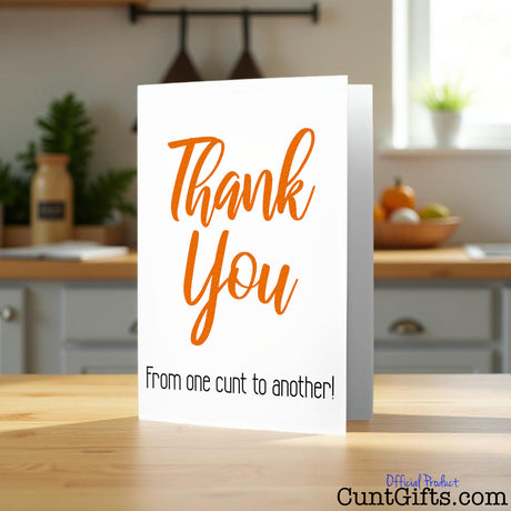 Thank You From One Cunt To Another Greetings Card on wooden counter.