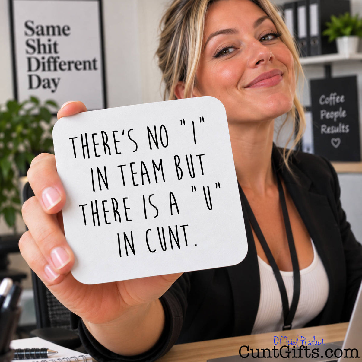 A woman in a black blazer and white top holds up a square white drink coaster with rounded corners that reads, 'THERE'S NO "I" IN TEAM BUT THERE IS A "U" IN CUNT.' in black handwritten-style text.