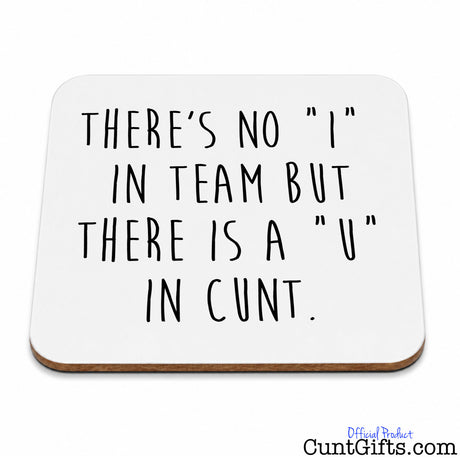 A square white coaster with rounded corners and a thin brown wood edge, printed with the humorous phrase 'THERE'S NO "I" IN TEAM BUT THERE IS A "U" IN CUNT.' in black handwritten-style lettering.