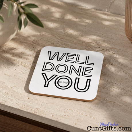 Well Done You Cunt - Drinks coaster  on stone worktop next to plant.