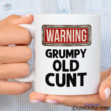 Warning - Grumpy Old Cunt - Mug held by woman in small striped shirt