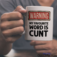 Warning my favourite word is cunt - Mug being held by man in grey t-shirt
